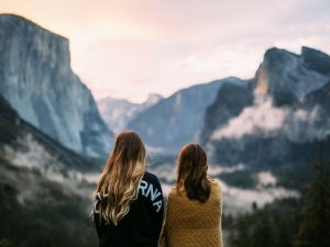 Two women look out at a vista of mountains